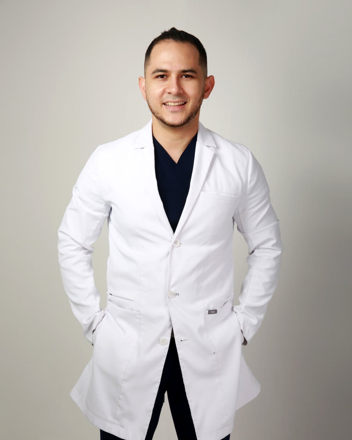 Dr. Pedro León Amaya con bata médica blanca, sonriendo